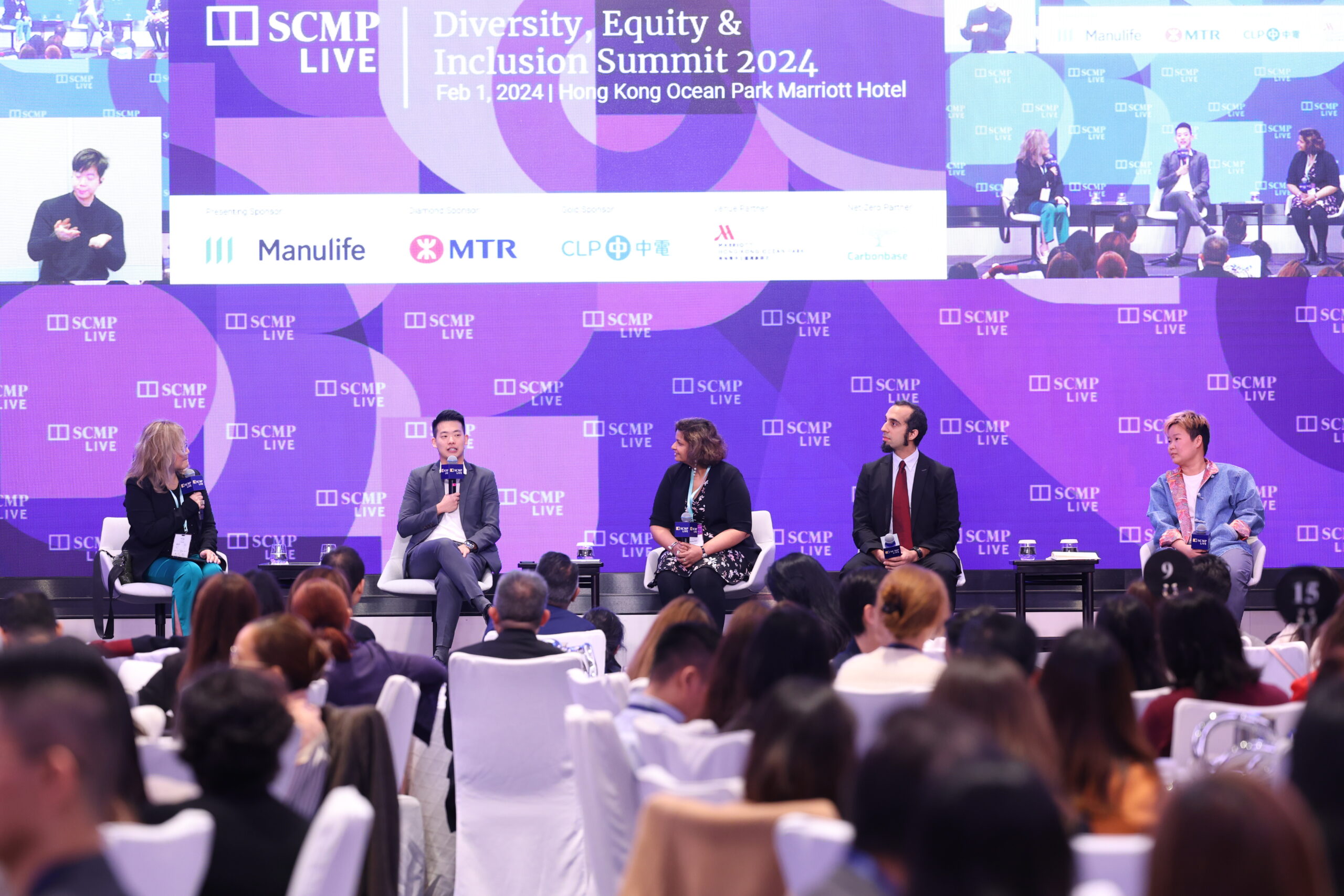 Emery speaking on stage for a SCMP panel